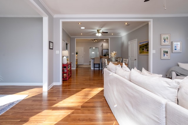 living room with ceiling fan, wood-type flooring, and crown molding