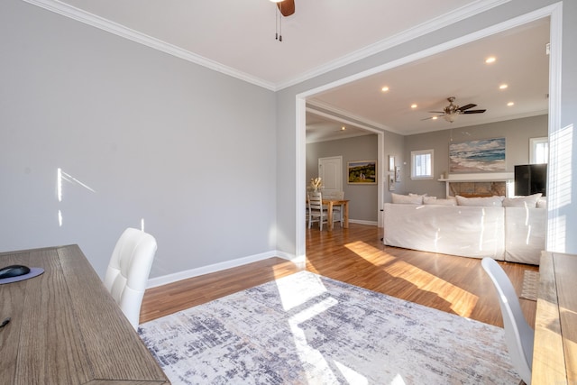 office space with ceiling fan, light wood-type flooring, and crown molding