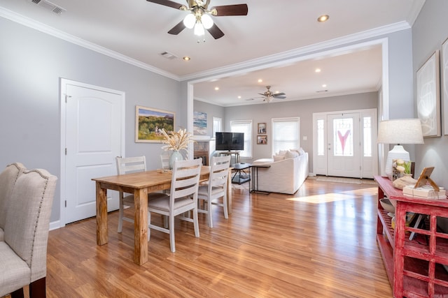 dining space with ceiling fan, light wood-type flooring, and crown molding