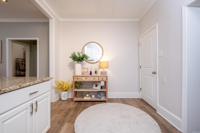 living area with hardwood / wood-style floors and crown molding