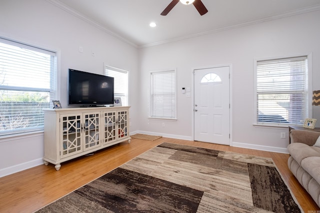 living room with light hardwood / wood-style floors, ceiling fan, and ornamental molding