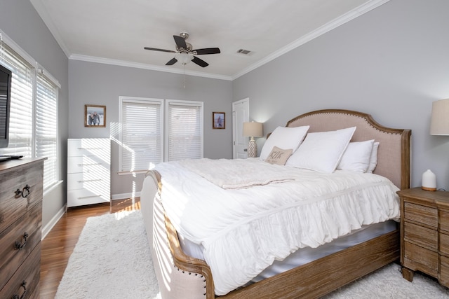 bedroom with ceiling fan, crown molding, and dark wood-type flooring