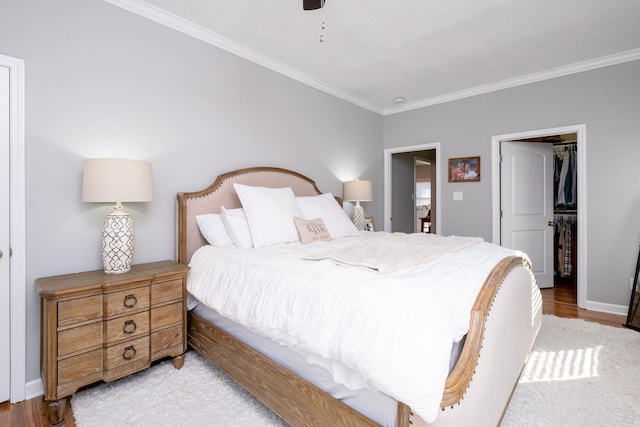 bedroom with a closet, light hardwood / wood-style floors, ceiling fan, and ornamental molding