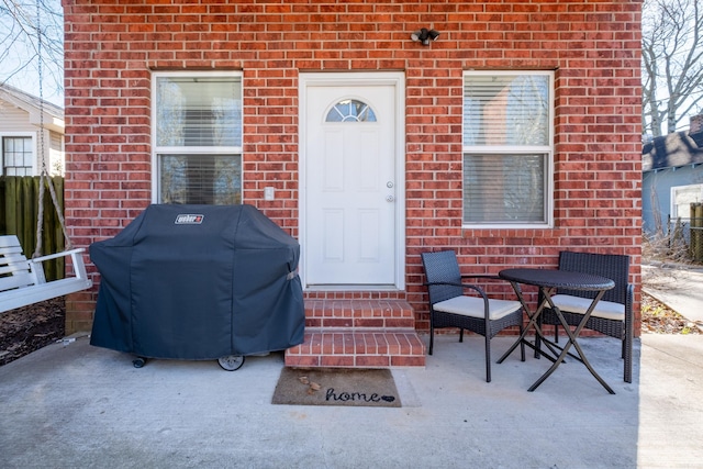 view of exterior entry with a patio area