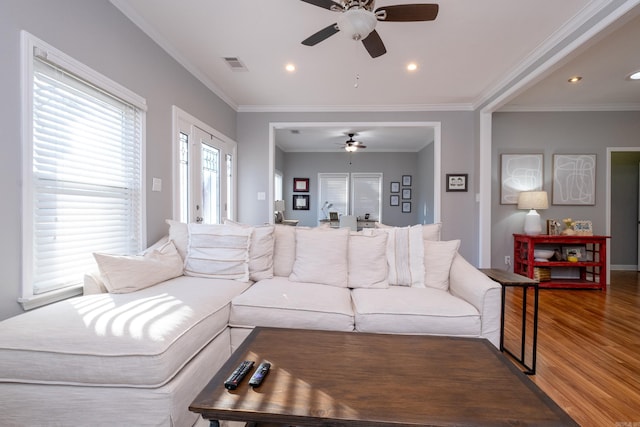 living room featuring dark hardwood / wood-style floors, ceiling fan, and ornamental molding