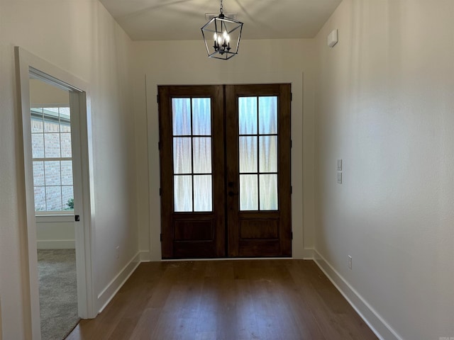 entryway featuring dark hardwood / wood-style flooring, a notable chandelier, and french doors