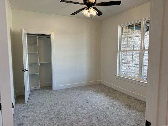 unfurnished bedroom featuring light colored carpet, ceiling fan, and multiple windows