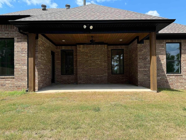 rear view of property with a yard, ceiling fan, and a patio