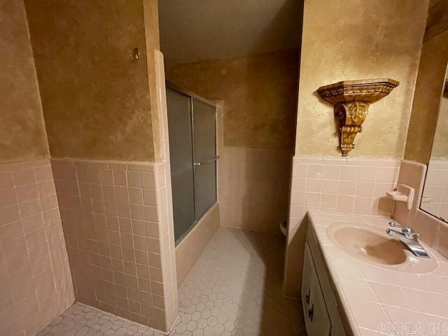 bathroom featuring walk in shower, tile floors, large vanity, and tile walls