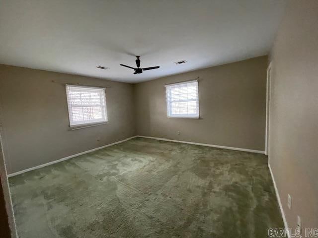 carpeted spare room featuring ceiling fan