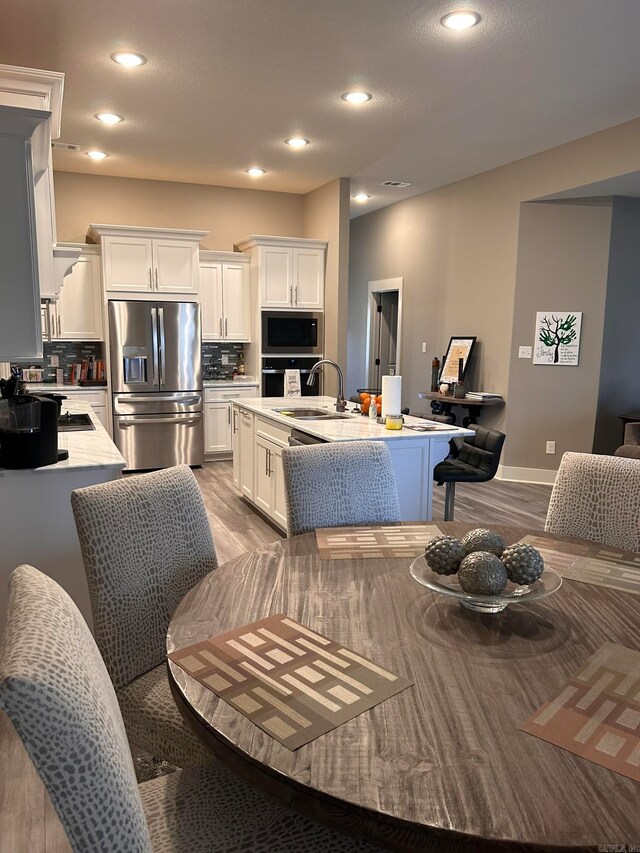 dining space with sink and light wood-type flooring