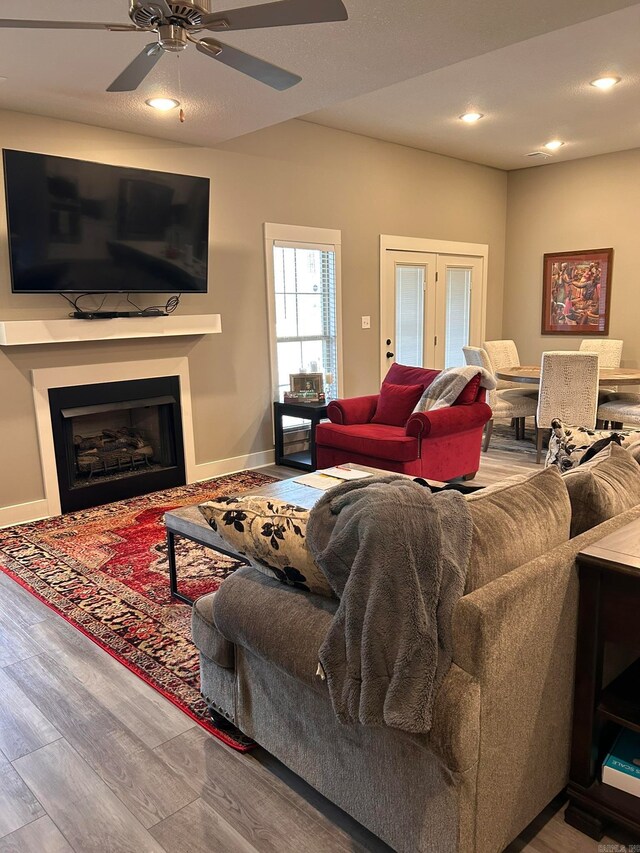 living room featuring ceiling fan, light hardwood / wood-style flooring, and french doors