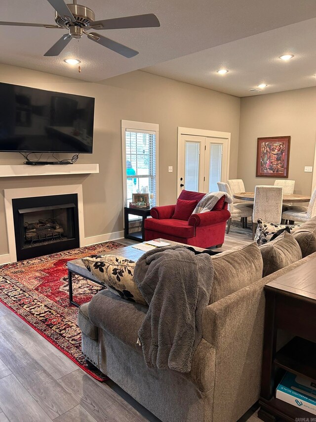 living room with ceiling fan, light wood-type flooring, and french doors