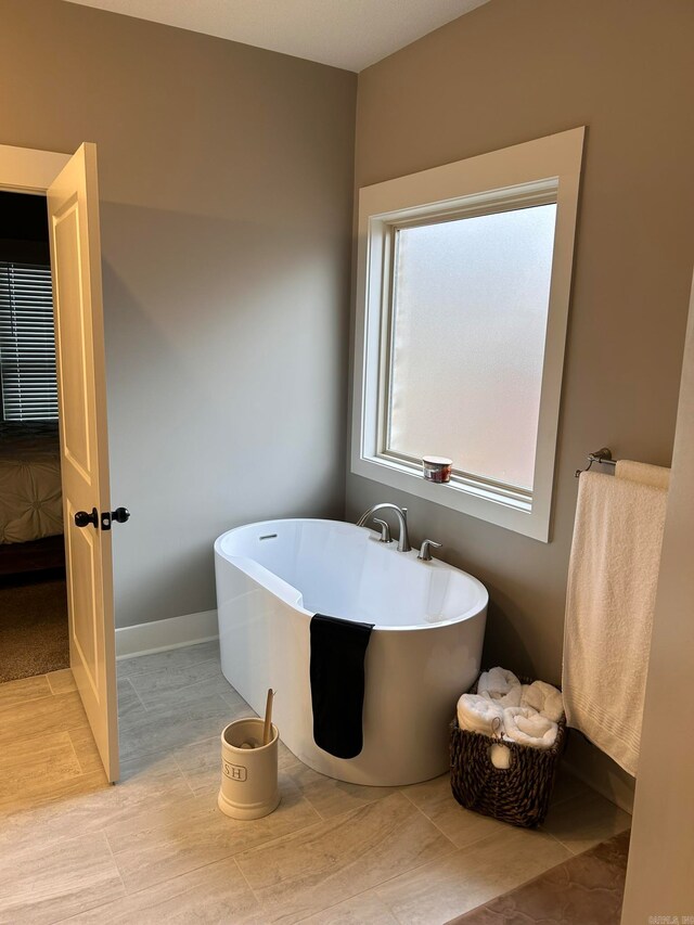 bathroom with tile flooring and a bathtub