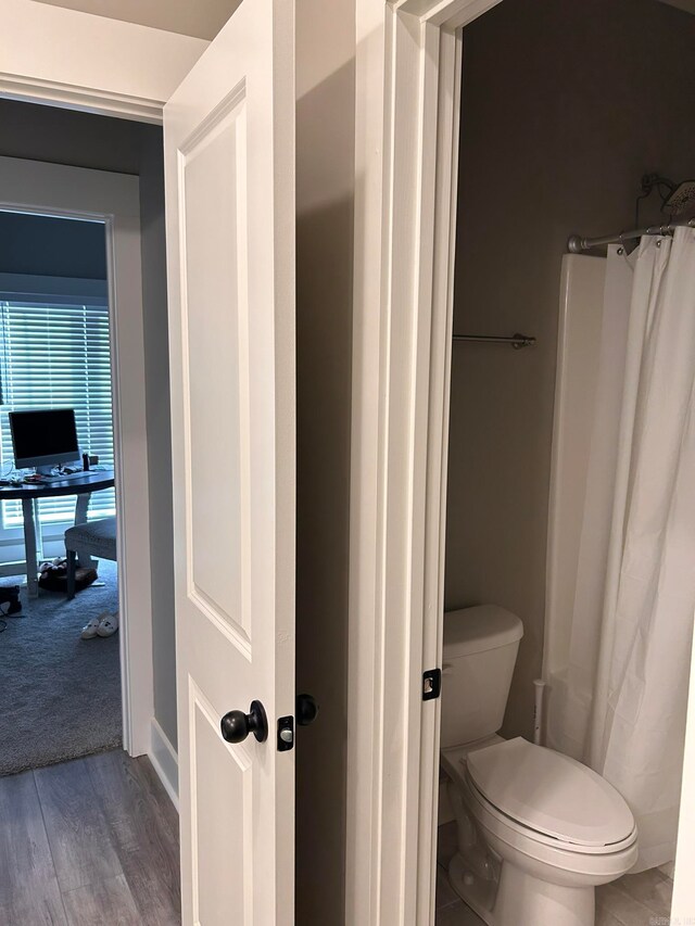 bathroom with hardwood / wood-style floors and toilet