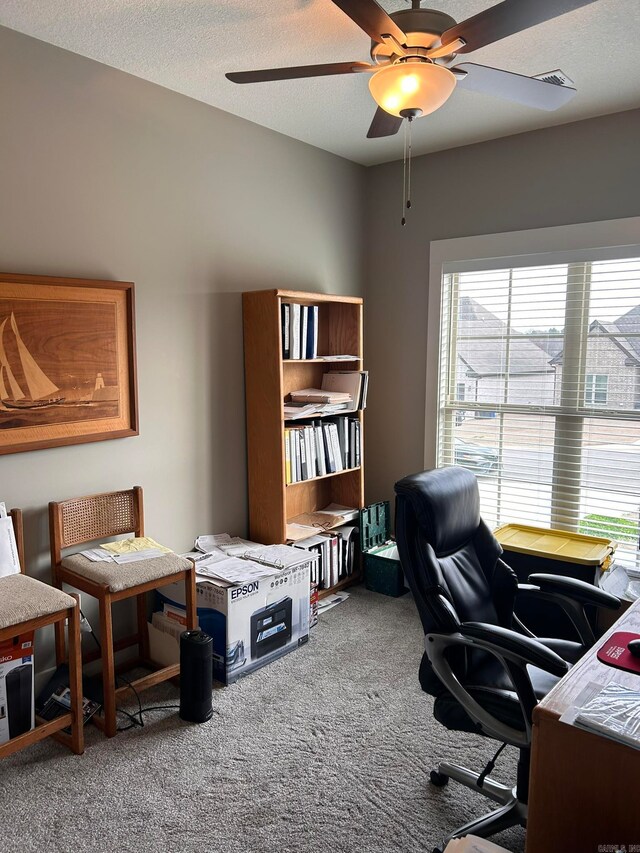 carpeted office with ceiling fan and a textured ceiling