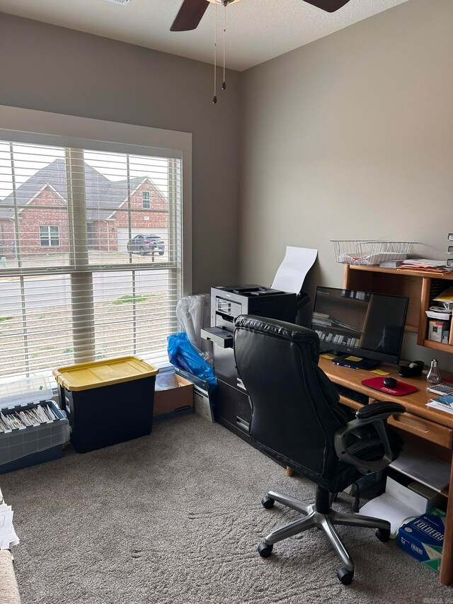 carpeted home office featuring ceiling fan