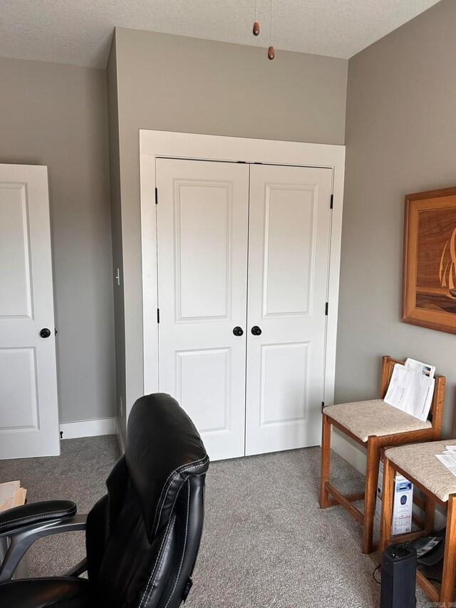 carpeted office featuring a textured ceiling