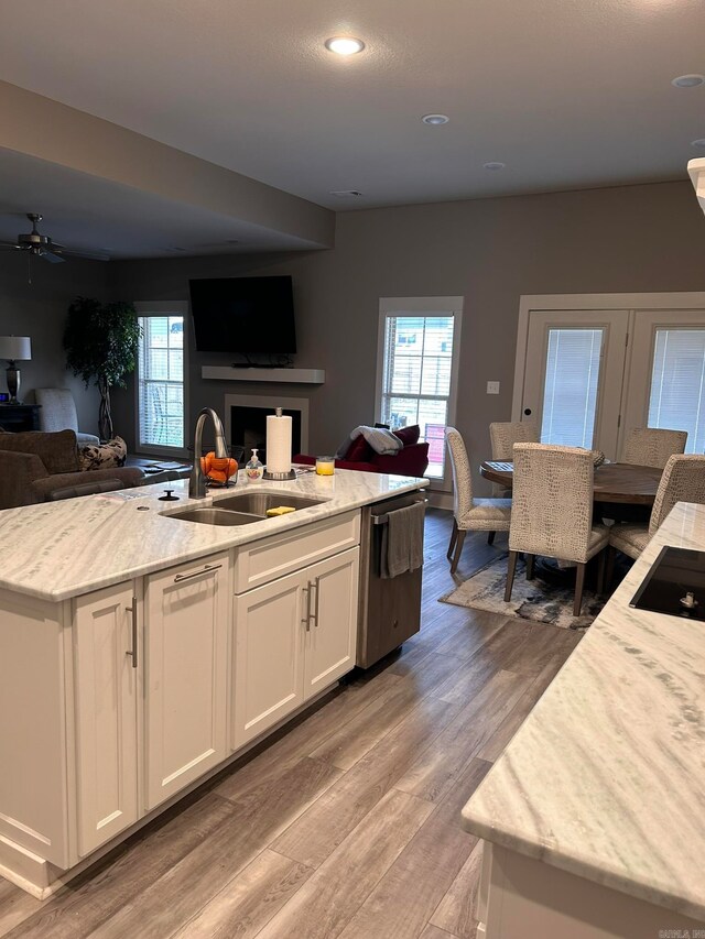 kitchen featuring ceiling fan, white cabinetry, sink, and hardwood / wood-style floors