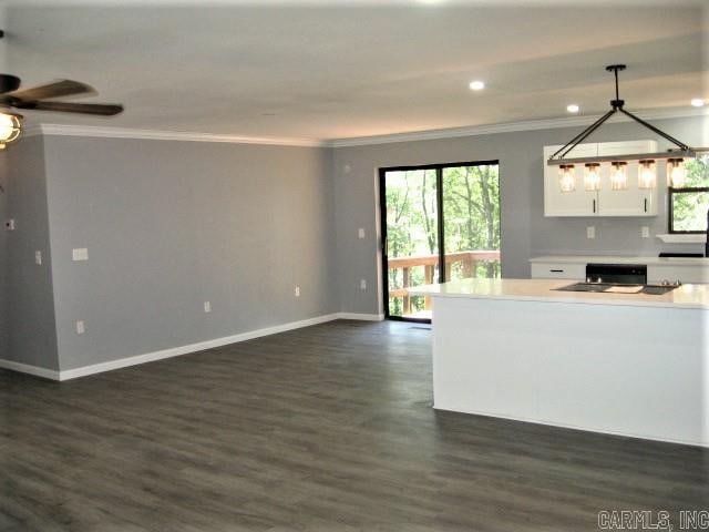 kitchen with a healthy amount of sunlight, pendant lighting, dark wood-type flooring, and white cabinetry