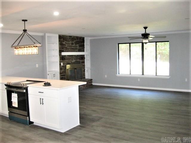 kitchen featuring dark wood-type flooring, a fireplace, electric stove, and white cabinets