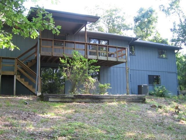 back of house with a wooden deck and central AC unit