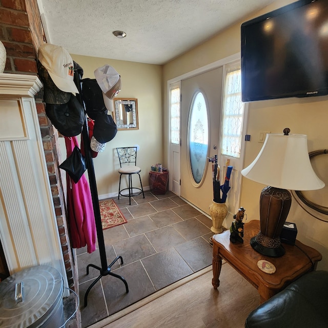 foyer with a textured ceiling and dark tile flooring