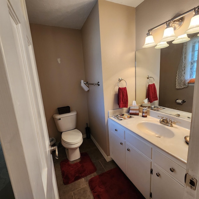 bathroom featuring tile flooring, toilet, and vanity with extensive cabinet space