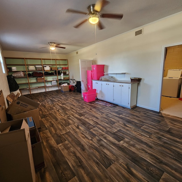 interior space with dark hardwood / wood-style floors, ceiling fan, and washer / dryer