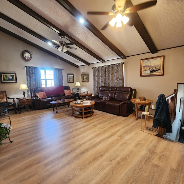 living room featuring a textured ceiling, ceiling fan, vaulted ceiling with beams, and light wood-type flooring