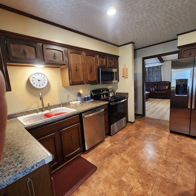 kitchen featuring crown molding, appliances with stainless steel finishes, light hardwood / wood-style floors, and sink