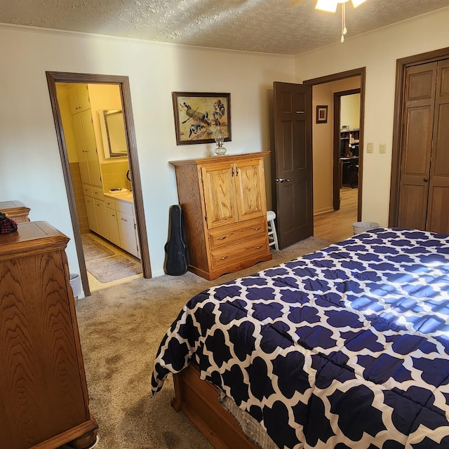 bedroom featuring a textured ceiling, connected bathroom, and light carpet