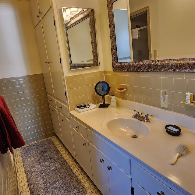 bathroom with backsplash, tile flooring, vanity, and tile walls