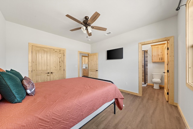 bedroom featuring ceiling fan, light wood-type flooring, connected bathroom, and a closet