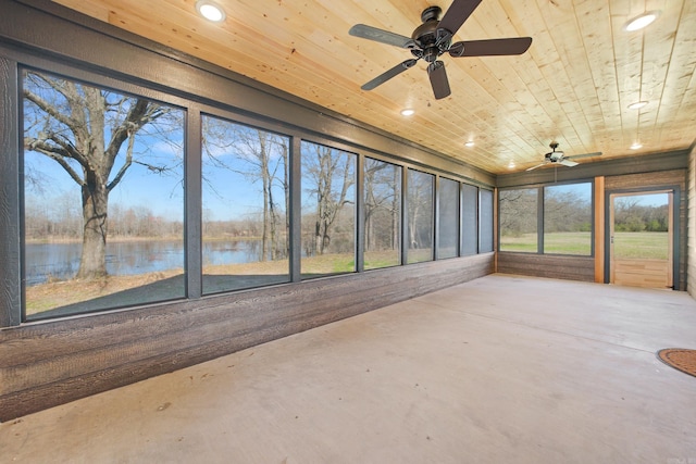 unfurnished sunroom featuring wooden ceiling, a water view, and ceiling fan