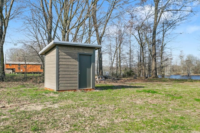 view of outdoor structure featuring a water view and a yard