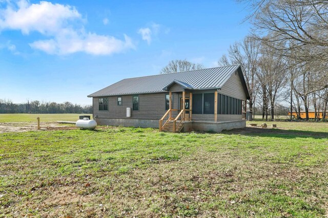 view of front facade with a front lawn and a sunroom