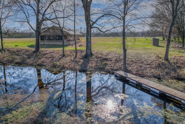 view of yard with a water view and a boat dock