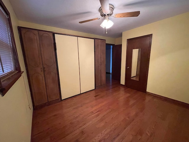 unfurnished bedroom featuring dark hardwood / wood-style flooring and ceiling fan