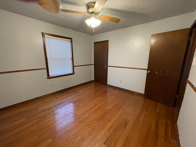 unfurnished bedroom with ceiling fan and light wood-type flooring