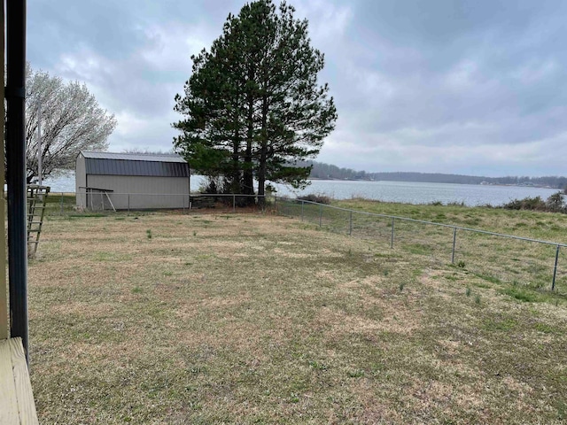 view of yard featuring a water view and a storage unit