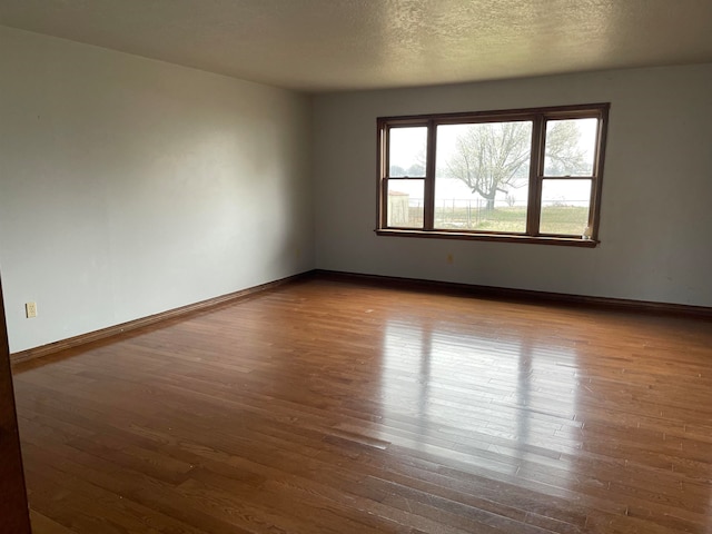 spare room with wood-type flooring and a textured ceiling