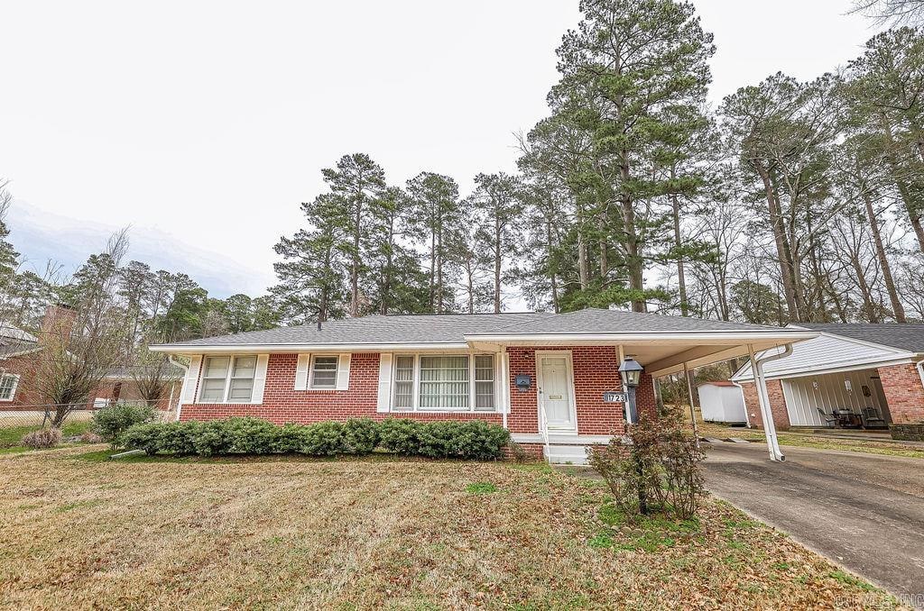 view of front of home with a carport, covered porch, and a front yard