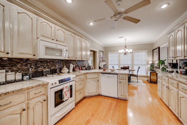 kitchen with kitchen peninsula, white appliances, pendant lighting, ceiling fan with notable chandelier, and light wood-type flooring