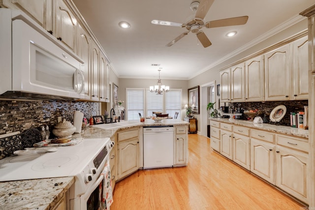 kitchen featuring hanging light fixtures, ceiling fan with notable chandelier, white appliances, light hardwood / wood-style floors, and tasteful backsplash