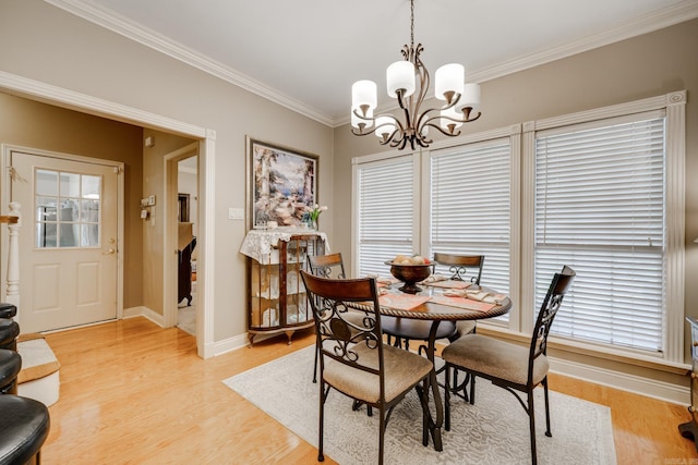 dining room with light wood-type flooring, ornamental molding, a chandelier, and a wealth of natural light