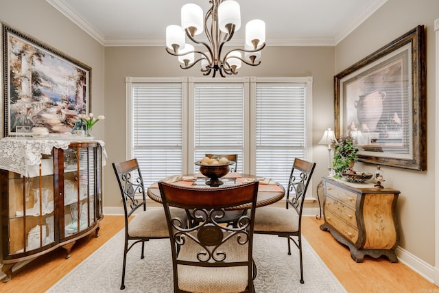 dining area featuring a chandelier, light hardwood / wood-style floors, and crown molding