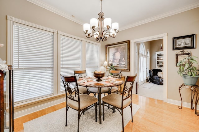 dining space with light hardwood / wood-style flooring, ornamental molding, and a notable chandelier