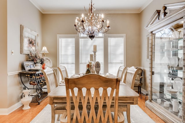 dining space with a notable chandelier, crown molding, and light wood-type flooring