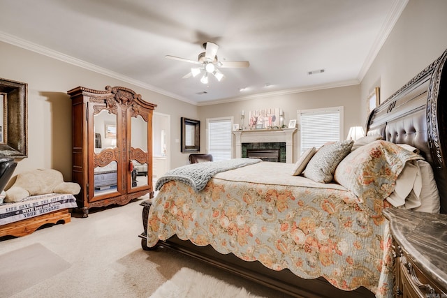 carpeted bedroom with ceiling fan, crown molding, a tile fireplace, and multiple windows